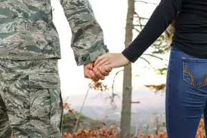 A veteran holds hands with a person in jeans