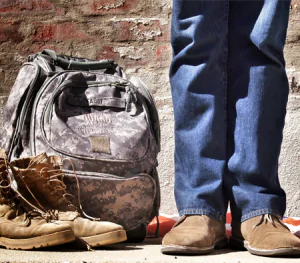 Veteran standing next to ACU carry bag and boots.